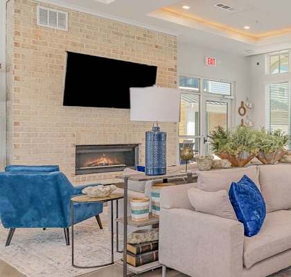 A living room with a fireplace and a flat screen TV mounted on the wall.