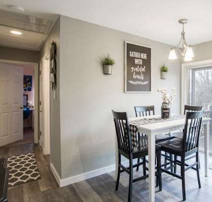 A kitchen with a dining table and chairs.