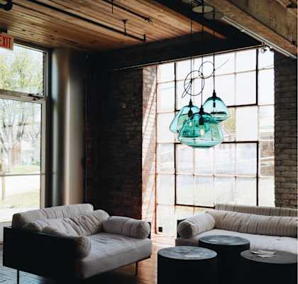 A living room with a white couch and a glass chandelier.