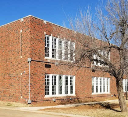 A red brick building with a white door and windows.