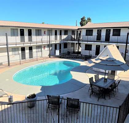 A pool area with chairs and a table.