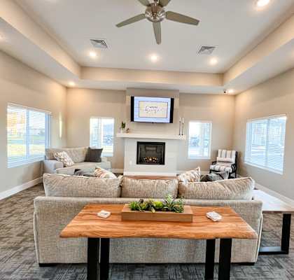 a living room with couches and a table in front of a fireplace