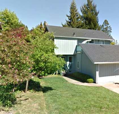 A house with a grey roof and a white garage door.
