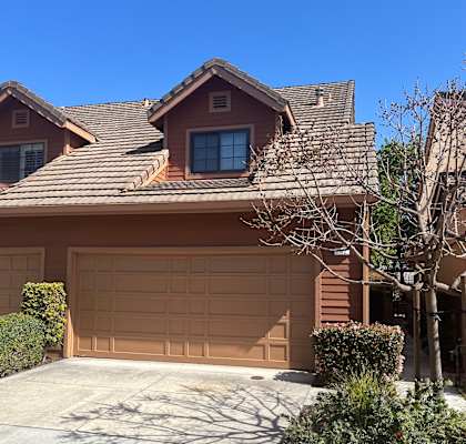 A brown house with a tan garage door.