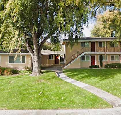 a house with a yard and trees in front of it