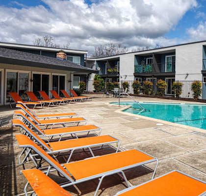 A pool surrounded by orange sun loungers.