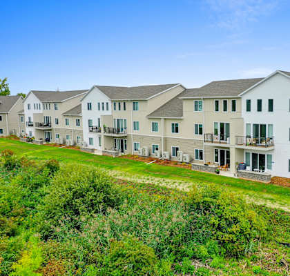 a row of apartment buildings on a grassy hill
