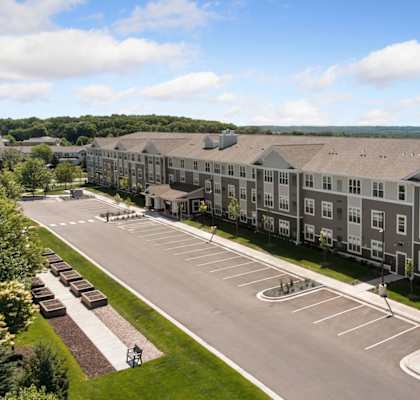 A large apartment complex with a parking lot in front.