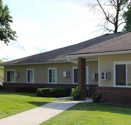 Mayer Elderly Complex with a grey roof and a grey pole in front of it.
