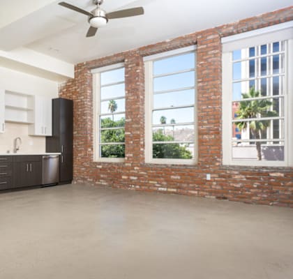 A kitchen with a refrigerator, microwave, oven, and cabinets. at Imperial Hardware Lofts, California, 92501