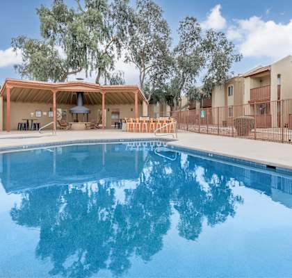 A swimming pool in front of a building with a fence around it.