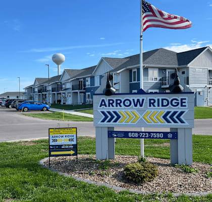 A sign for Arrow Ridge with a phone number on it. apartment building in lancaster wisconsin