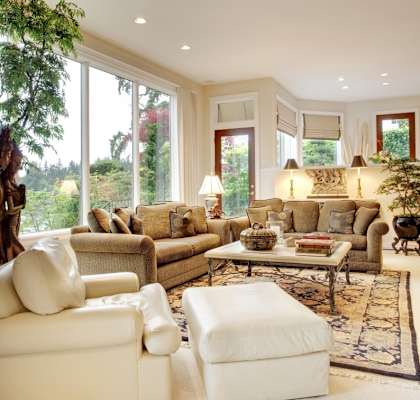 A living room with a large window and a view of trees.