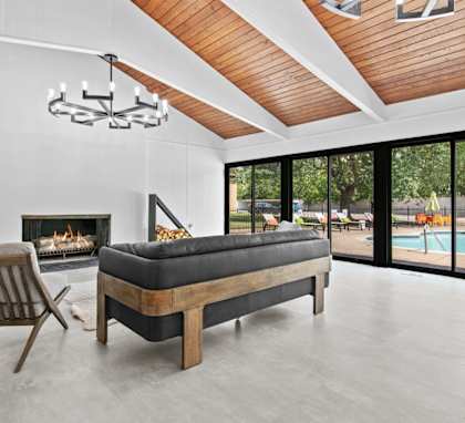 a living room with a couch and chairs in front of a fireplace