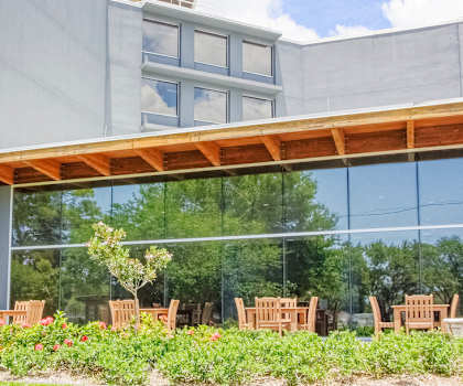 St. Giles Manor exterior with large glass windows and outside tables and landscaping