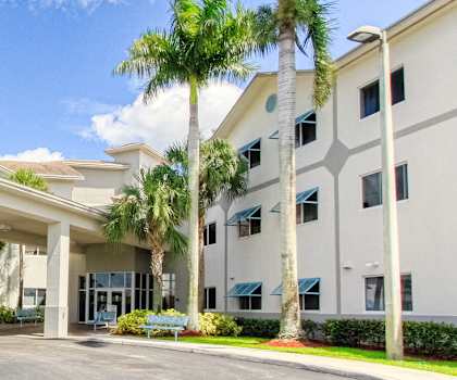 Exterior of Villa Regina with covered drive and lush palms