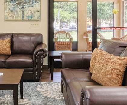 lobby with comfortable leather couches, coffee table, and large windows for natural light