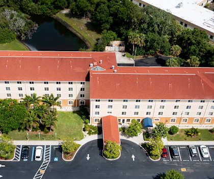 Villa San Marcos Apartments with ample parking, lush landscaping, and ponds