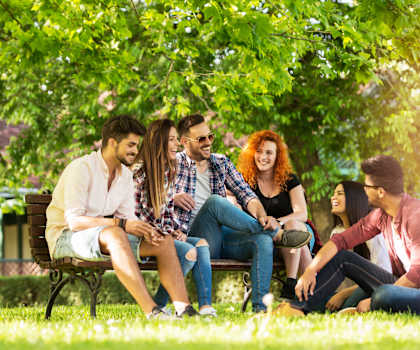 a group of people sitting on a park bench at The Clairborne Apartment Homes, Grand Prairie, TX, 75050
