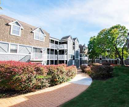 A pathway leads through a grassy area between two buildings.