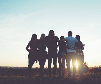 A group of people are silhouetted against the sunset at The Madison Apartments and Townhomes, Georgia