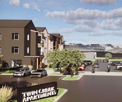 A rendering of Twin Creek Apartments complex with cars parked in the parking lot.