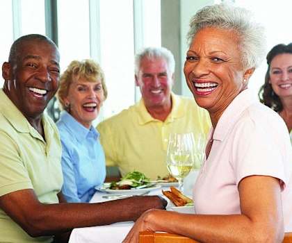 a group of people sitting at a table with food