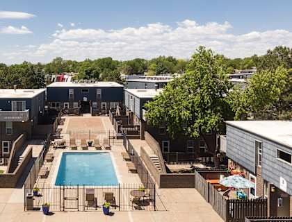 an aerial view of a swimming pool in the center of an apartment complex