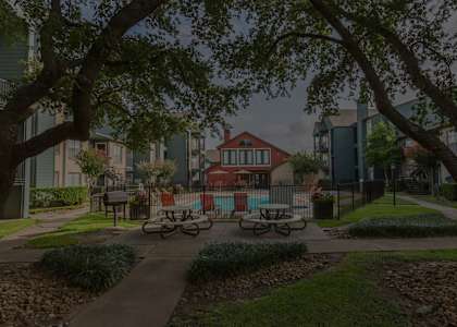 Outdoor community space with tables and view of fenced pool