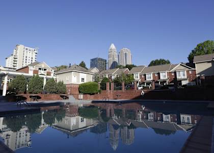A pool in a residential area with buildings in the background.