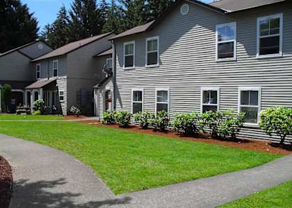 a gray house with a yard and a sidewalk