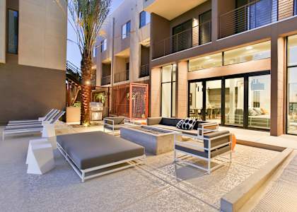 a lounge area with couches and chairs in front of a building