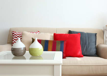 a living room with a couch and pillows and a coffee table