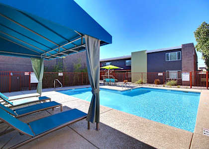 A pool area with a blue canopy and a small pool.