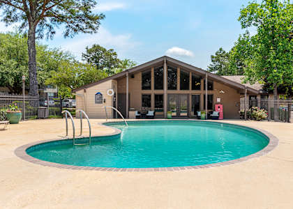 A small building with a pool in front of it at Lakeshore Landing Apartments, Ridgeland, Mississippi