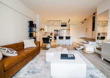 a living room with a brown couch and a white table at 21 E Chestnut, Chicago
