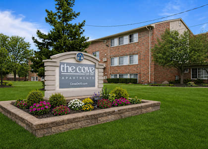 The Cove Apartments is a brick building with a sign in front.
