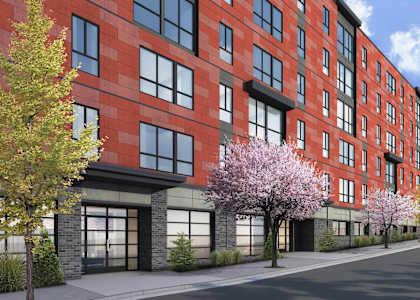 A red brick building with trees in front of it.