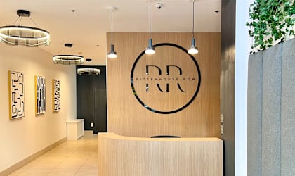 a reception desk in a hotel lobby with a clock on the wall