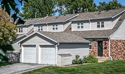 a white house with two garages and a driveway