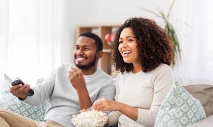 a couple sitting on a couch eating popcorn and watching tv at Bedford Castle, Bedford Heights, Ohio