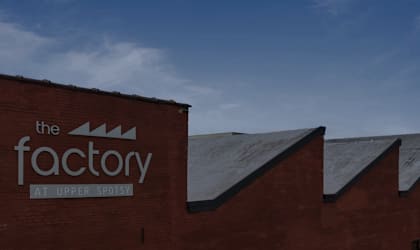 The factory at Upper Spotsy is a red brick building with a sign on the side.
