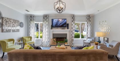 The clubhouse at The Onyx Hoover with ample seating, a TV, and a fireplace