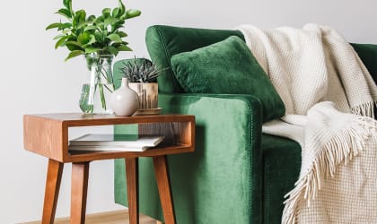 Green sofa with side table and plant