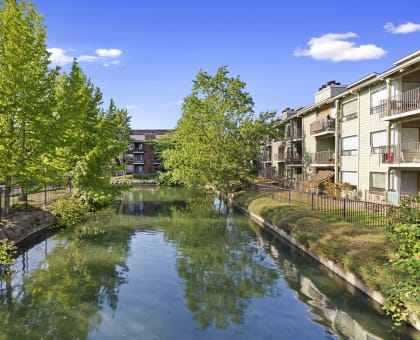 a canal surrounded by apartment buildings and trees