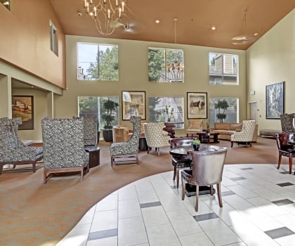 a large lobby with chairs and tables and windows
