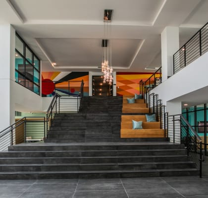 the lobby of a building with a large staircase and large windows