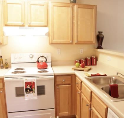 a kitchen with a white stove top oven next to a sink