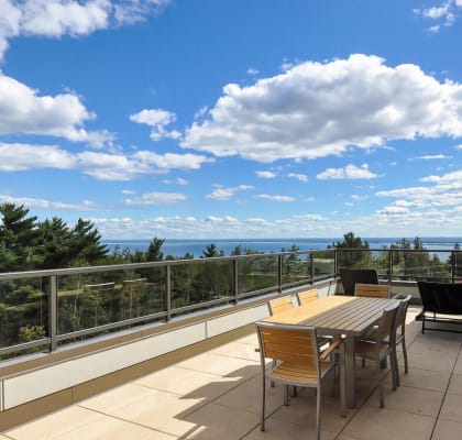 a patio with a table and chairs on a balcony overlooking the ocean at Bluestone Lofts, Minnesota, 55803