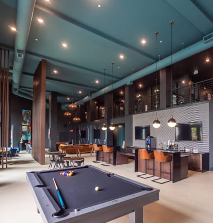 a clubhouse with a pool table and a bar